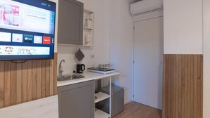 A compact kitchenette with a built-in TV, a coffee maker, and a small refrigerator.