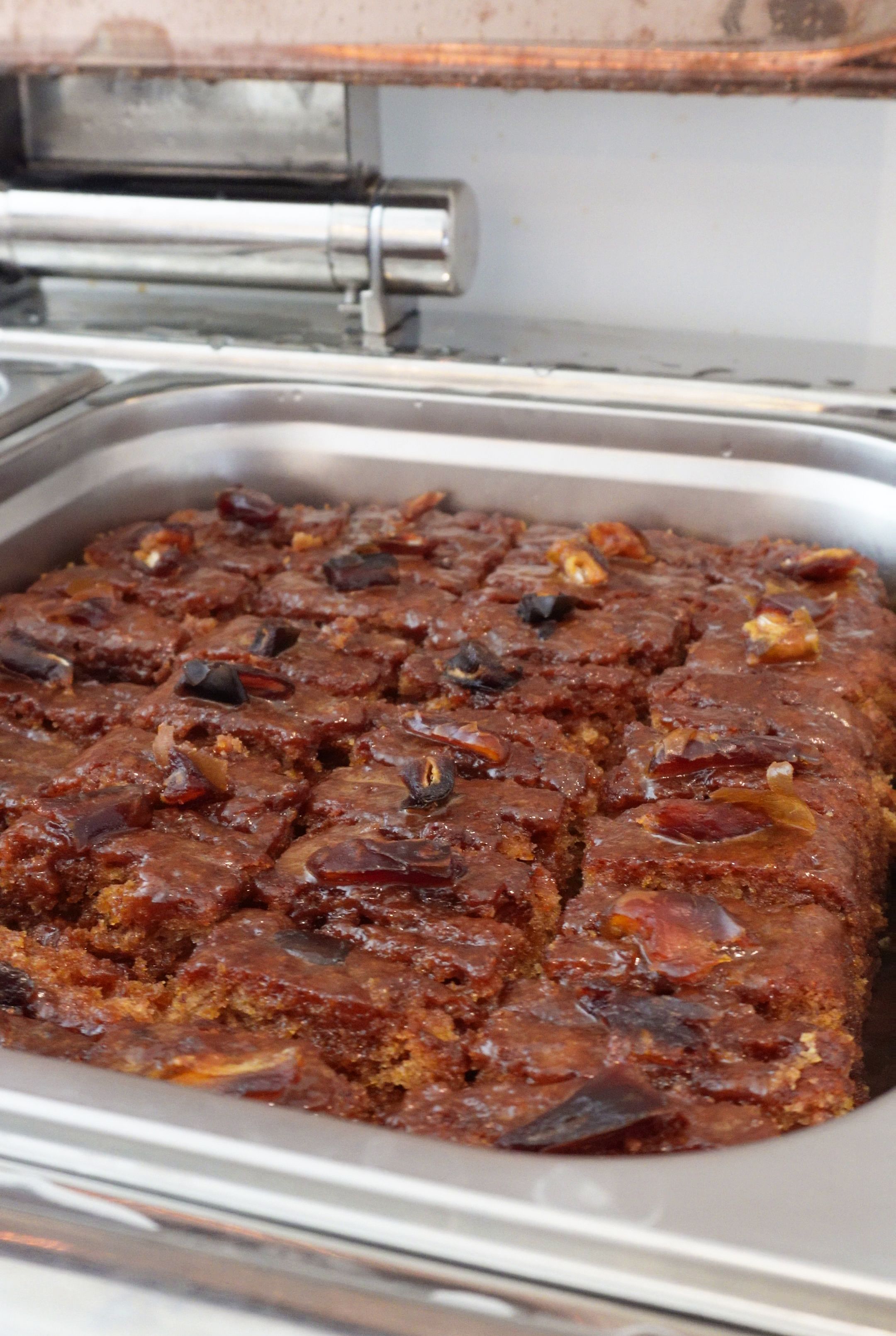 Una bandeja con alimentos, posiblemente un postre, que incluye una bandeja metálica y un asa.
