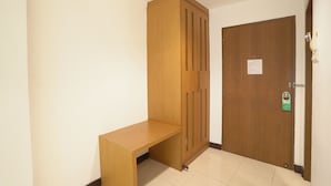 Une pièce avec une armoire en bois, un banc et une porte dotée d’une serrure et d’une pancarte.