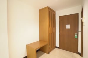 A room with a wooden wardrobe, a bench, and a door with a lock and a sign. - Blue Neptuna Hotel Patong by Koko (Patong)