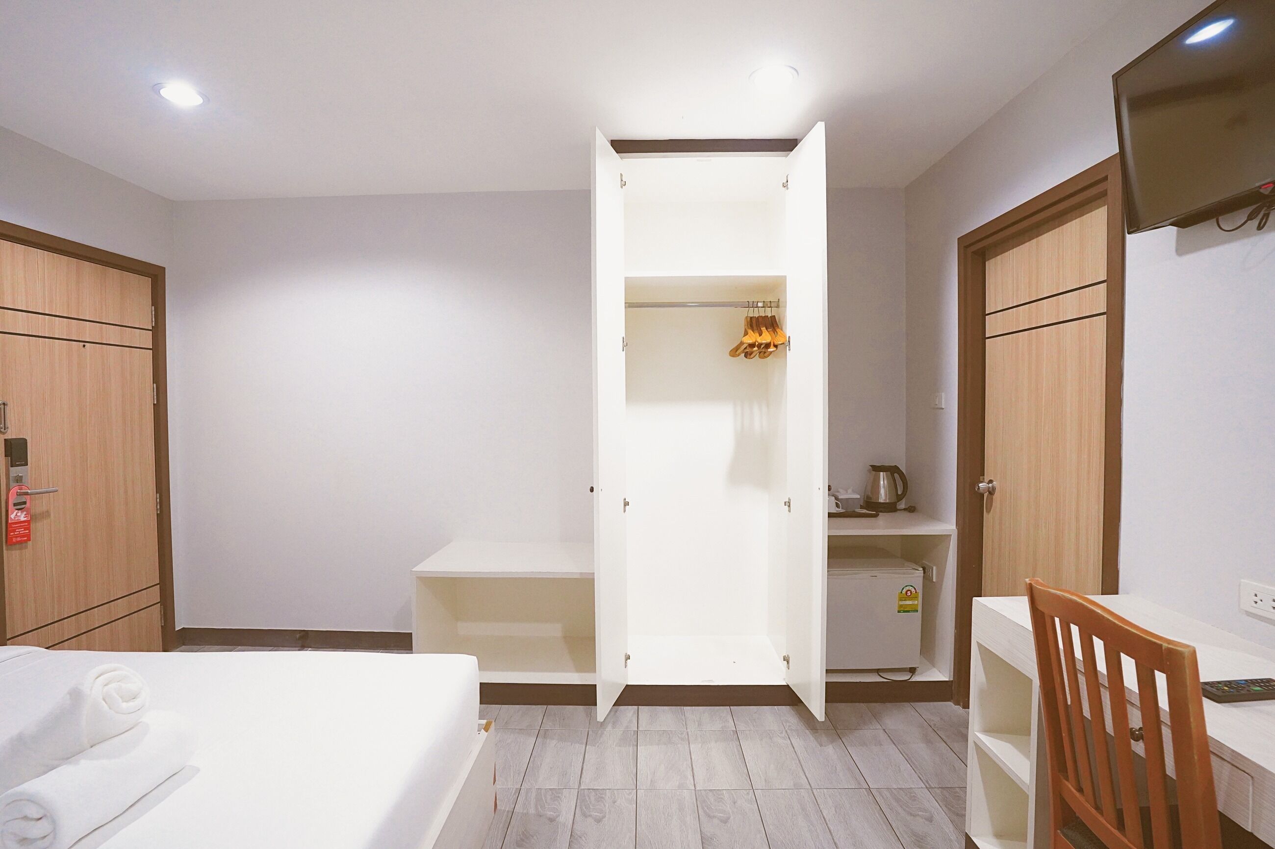 Ein Hotelzimmer mit Bett, Schreibtisch, Kleiderschrank und einer kleinen Küchenzeile.