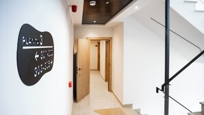 Un interior moderno con una escalera, un pasillo y un cartel que indica las direcciones hacia las habitaciones 301 y 302.