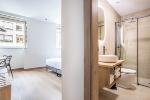Une salle de bain moderne avec une douche à parois de verre, un meuble-lavabo en bois et des toilettes.