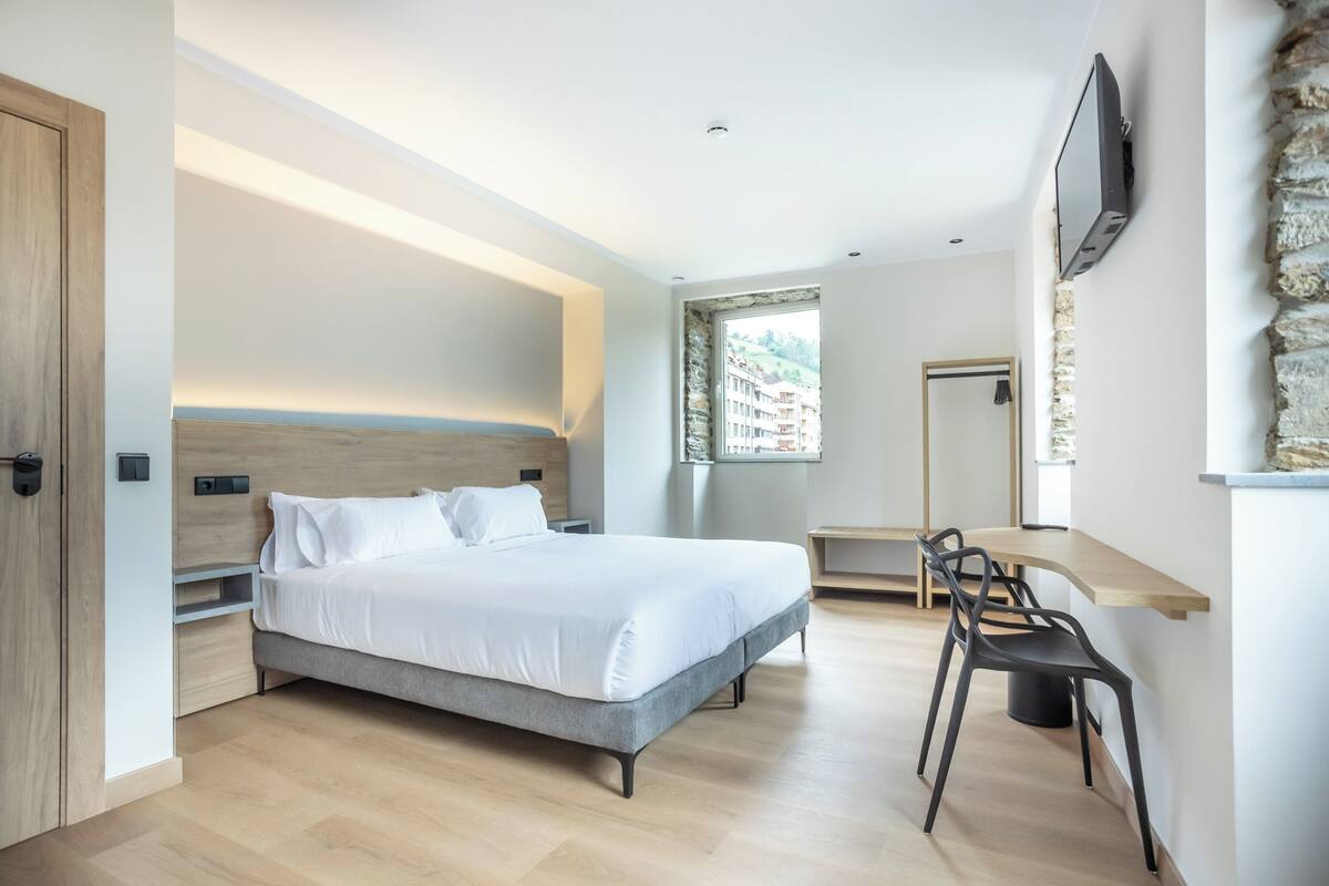Une chambre à coucher moderne avec un lit, un bureau et une chaise.