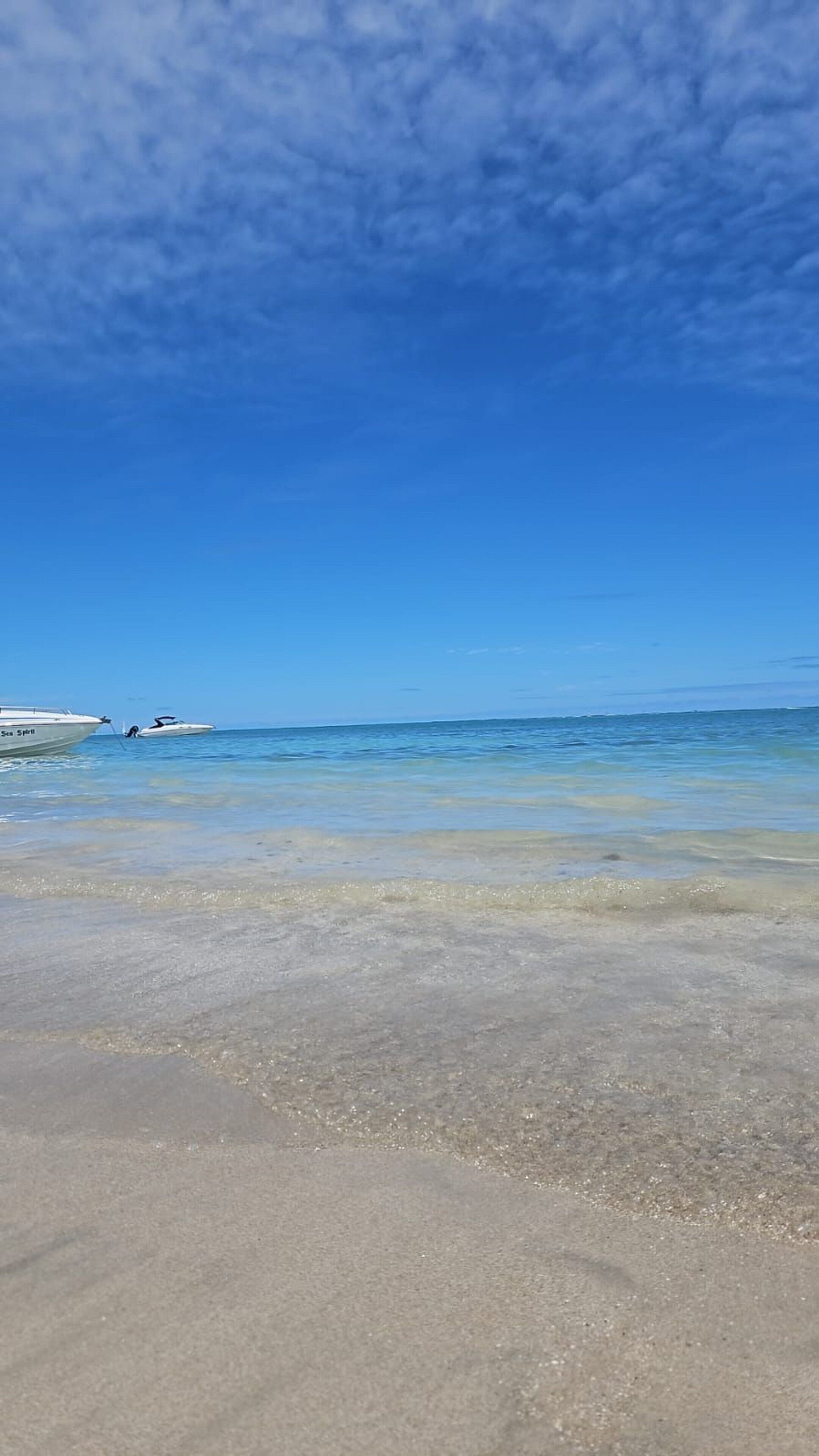 Na praia, areia branca, prática de mergulho livre no local 