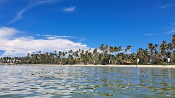 Na praia, areia branca, prática de mergulho livre no local