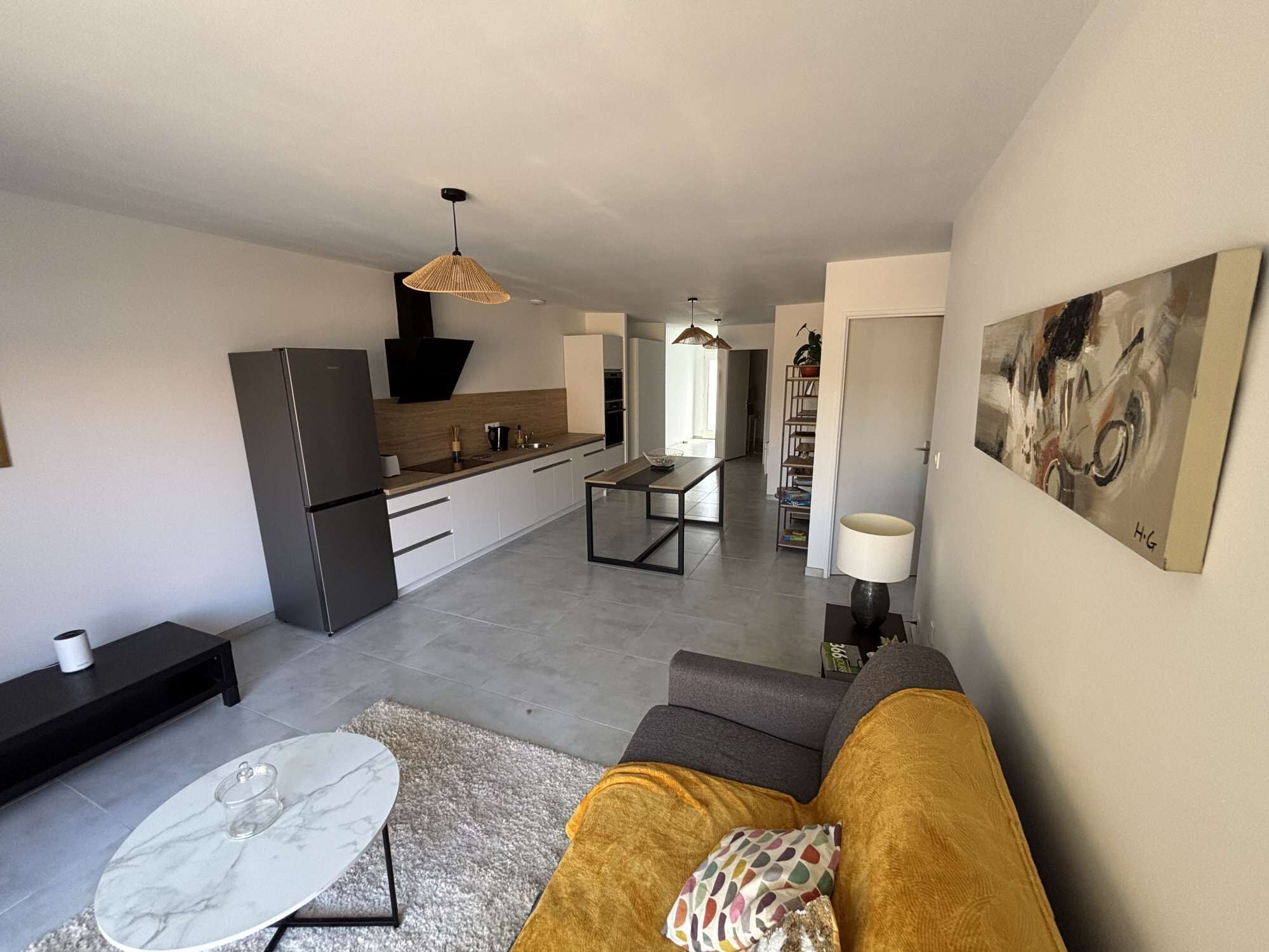 A modern apartment with a kitchen, dining area, living room, and a hallway leading to a bedroom.