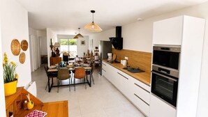 Een moderne keuken met witte kasten, een houten aanrechtblad en een ingebouwde oven.
