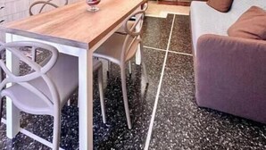 Espaço compacto com área de refeições, kitchenette e espaço para sentar.
