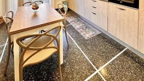 Uma cozinha moderna com uma mesa de jantar, cadeiras e um fogão.