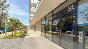 Een modern gebouw met een glazen gevel, huisnummer 31, en een keypad-deur.