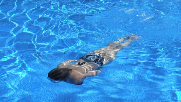 A person swimming in a clear blue pool. - GeojeResidenceHotel (Geoje)