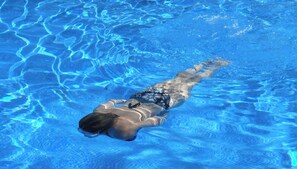 A person swimming in a clear blue pool. - GeojeResidenceHotel (Geoje)