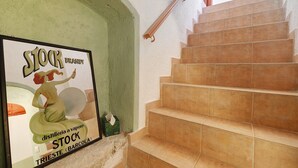 Una scala con piastrelle beige e una ringhiera, una parete verde e un poster pubblicitario.