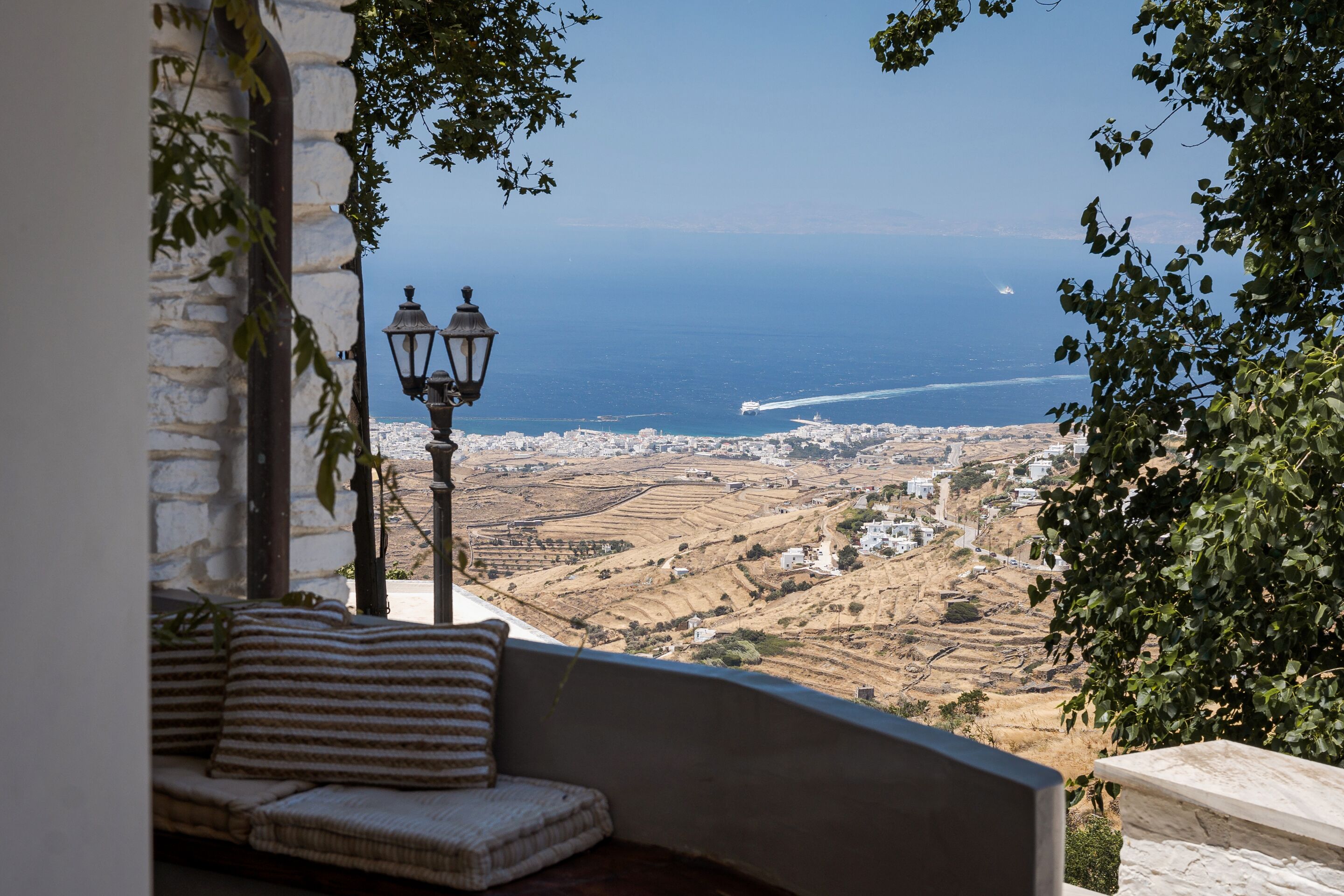 A balcony with a view of the sea and a cityscape.