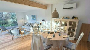 A dining area with a round table set for four, surrounded by white chairs. - Summer house near bathing jetty at Fynshoved (Martofte)