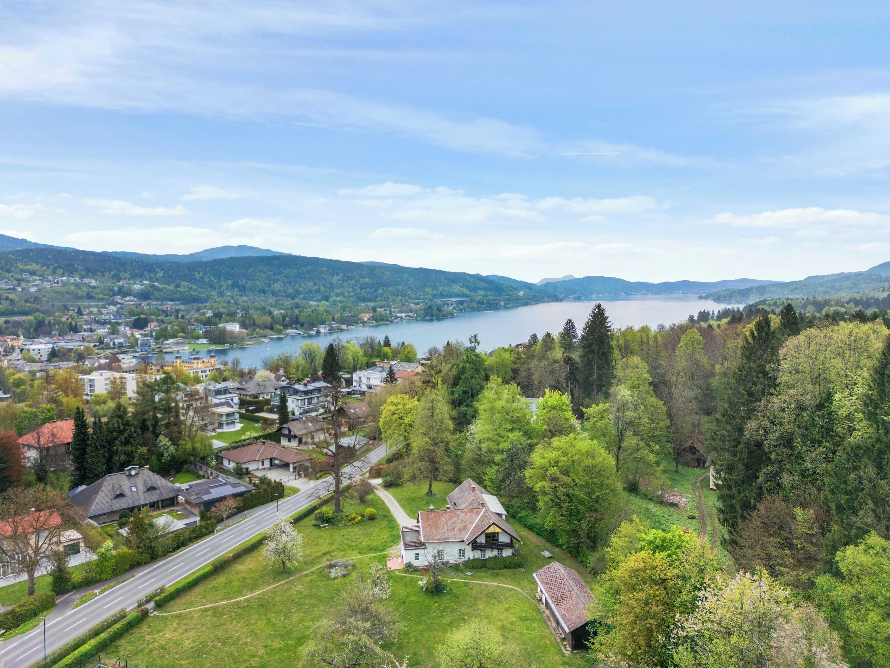 A residential area with houses, a road, and a lake in the background.