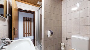 A bathroom with a sink, toilet, and shower area.