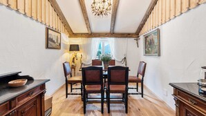 A dining area with a wooden ceiling, chandelier, and rustic decor.