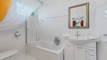 Un baño moderno con bañera, lavamanos e inodoro.