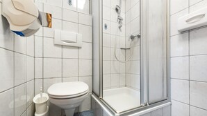 A bathroom with a toilet, a shower enclosure, and a toilet paper holder. - Hoiswirt: Family | Ski-in/out | Balcony | Sauna (Modriach)