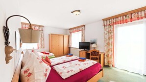 A bedroom with a bed, a television, a desk, and a wardrobe. - Hoiswirt: Family | Ski-in/out | Balcony | Sauna (Modriach)