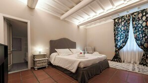 Ein Schlafzimmer mit Bett, Nachttisch und Vorhängen.