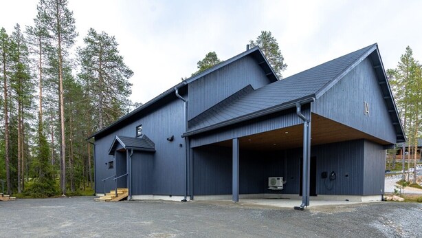 Een modern gebouw met een ruime garage en een overdekte entree.