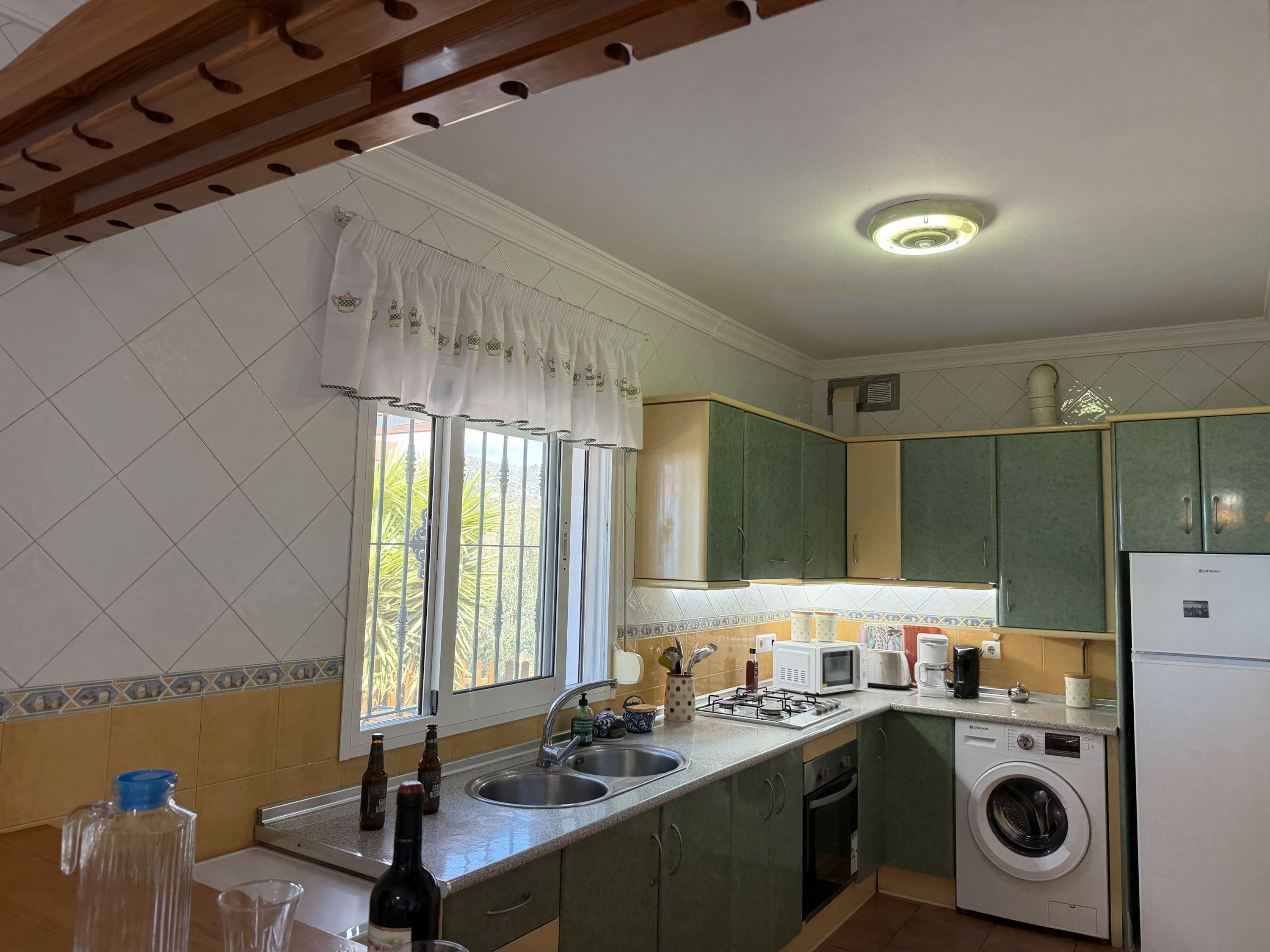 A kitchen with a sink, microwave, stove, and washing machine.
