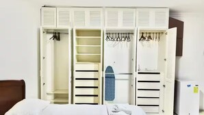 A hotel room with a bed, a wardrobe with multiple compartments, and a small ironing board. - Ideal for large groups : 450 sq. mts. apartment : Jacuzzi +2 parking spaces (Guayaquil)