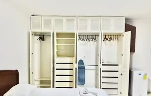 A hotel room with a bed, a wardrobe with multiple compartments, and a small ironing board. - Ideal for large groups : 450 sq. mts. apartment : Jacuzzi +2 parking spaces (Guayaquil)
