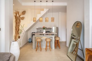 A modern kitchen with a central island, hanging pendant lights, and a large mirror. - Villa Arawan (Kerobokan)