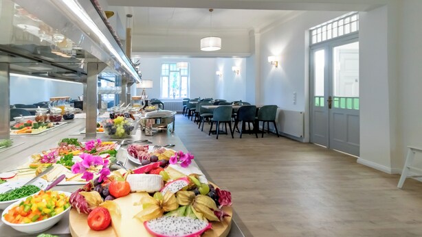 Un bufé con una variedad de alimentos y una zona de estar con mesas y sillas.