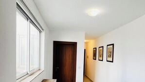 Ein Flur mit einer hölzernen Bank, einer Tür und gerahmten Bildern an der Wand.