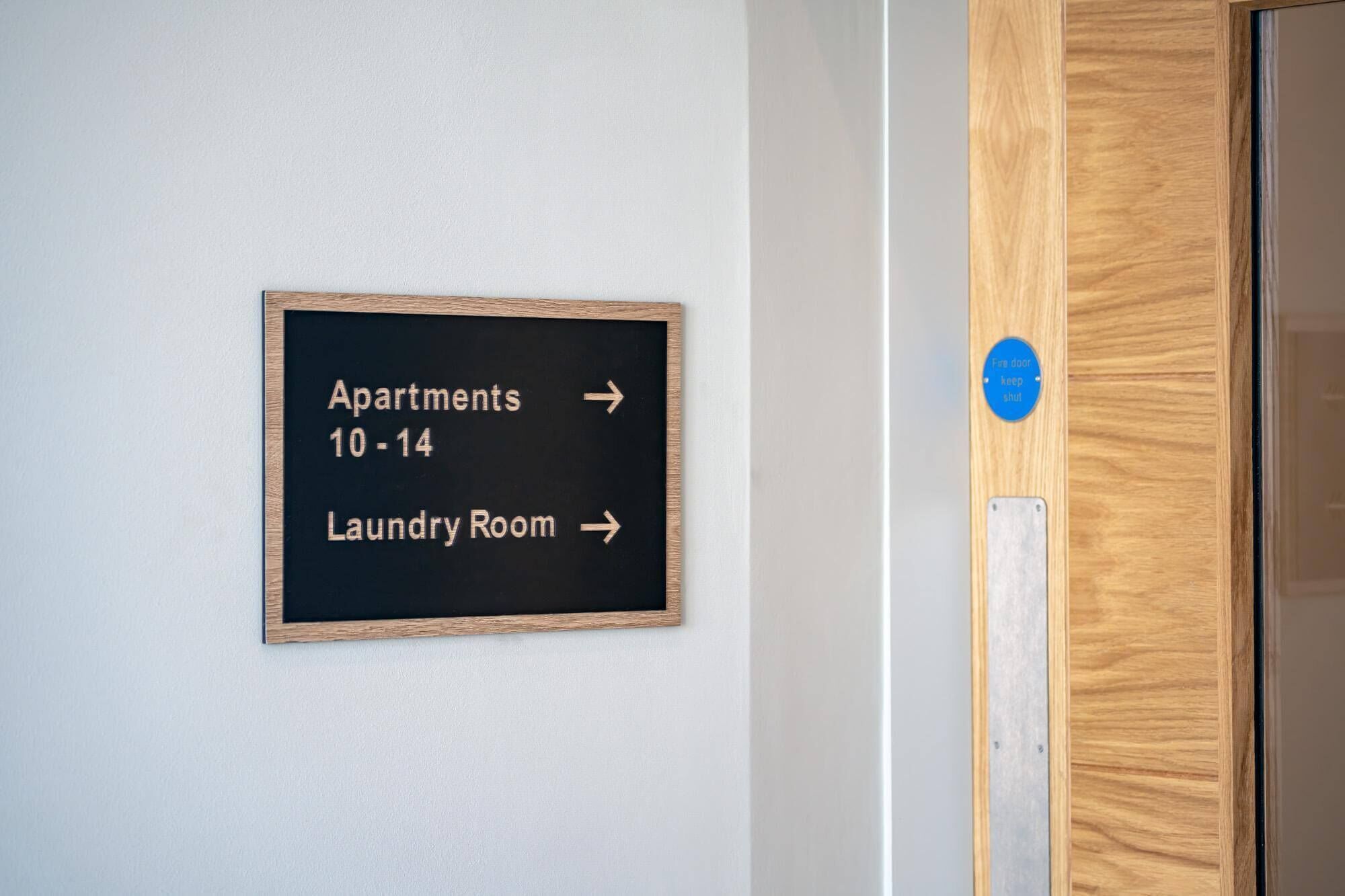 A sign with directions to apartments 10-14 and the laundry room.