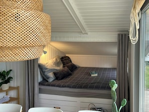 A cozy bedroom with a bed, pillows, a bedside table, a lamp, and a cactus. - Summer house 344 steps from beach near Saksild (Odder)