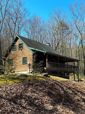 A log cabin with a porch and a deck, surrounded by trees. - Picture Rocks Log Cabin (Picture Rocks)