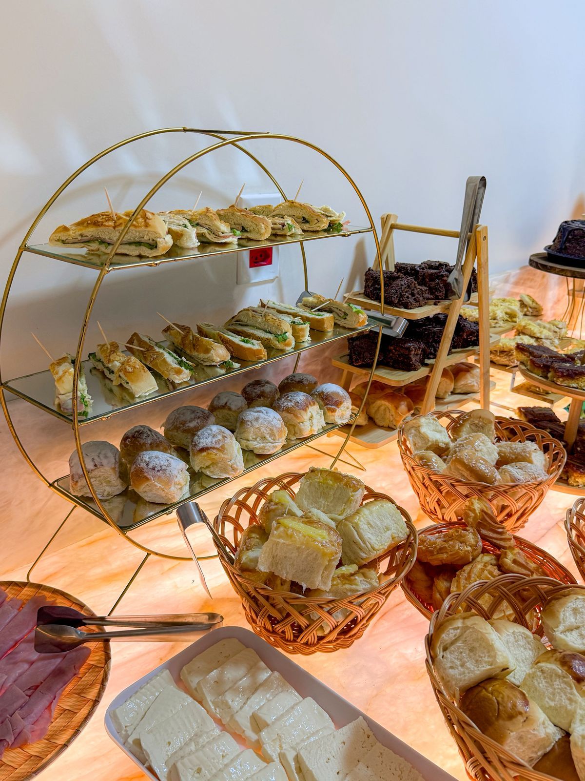 Un buffet proposant une variété de plats, notamment des sandwichs, des pâtisseries et des desserts.