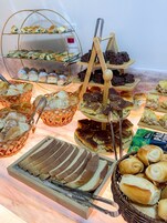 Buffet com diversas opções de comida, incluindo pães, doces e sobremesas.