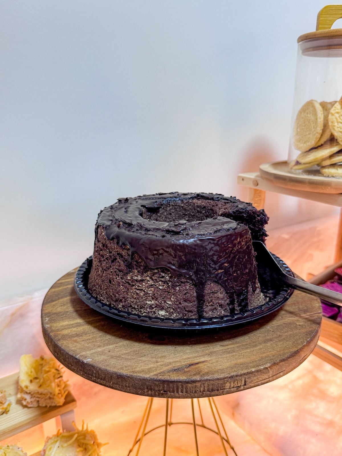 Un pastel de chocolate sobre un soporte de madera.