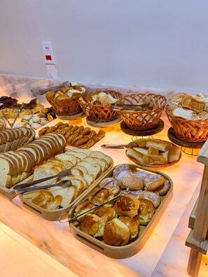 Un buffet proposant une variété de produits de boulangerie et de pâtisserie.