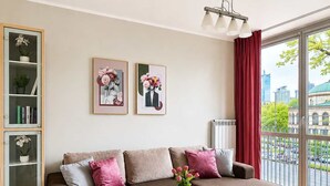 Ein modernes Wohnzimmer mit einem Ecksofa, einem Glastisch und einem Bücherregal.