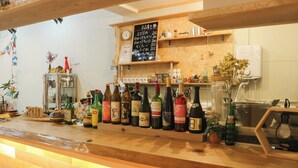 A bar area with various bottles of alcohol, a chalkboard menu, and shelves with items.