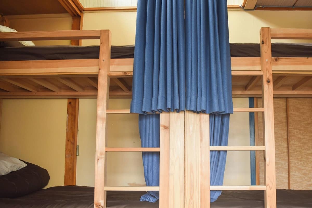 A bunk bed room with a curtain hanging in the middle.