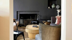 A living room with a fireplace, a sofa, a chair, and a coffee table. - Historic house in the heart of Provence (Brignoles)