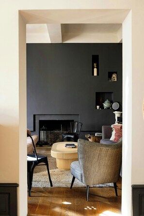 A living room with a fireplace, a sofa, a chair, and a coffee table. - Historic house in the heart of Provence (Brignoles)
