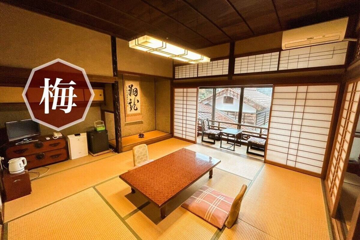 A traditional Japanese room with tatami flooring, a low table, and sliding doors.