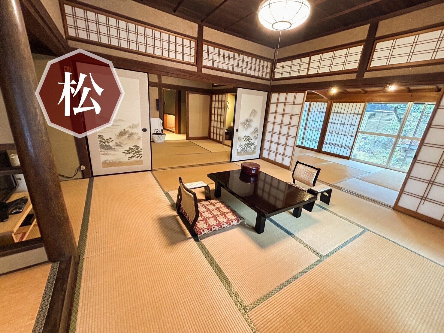 A traditional Japanese room with tatami flooring, a low table, and sliding doors.