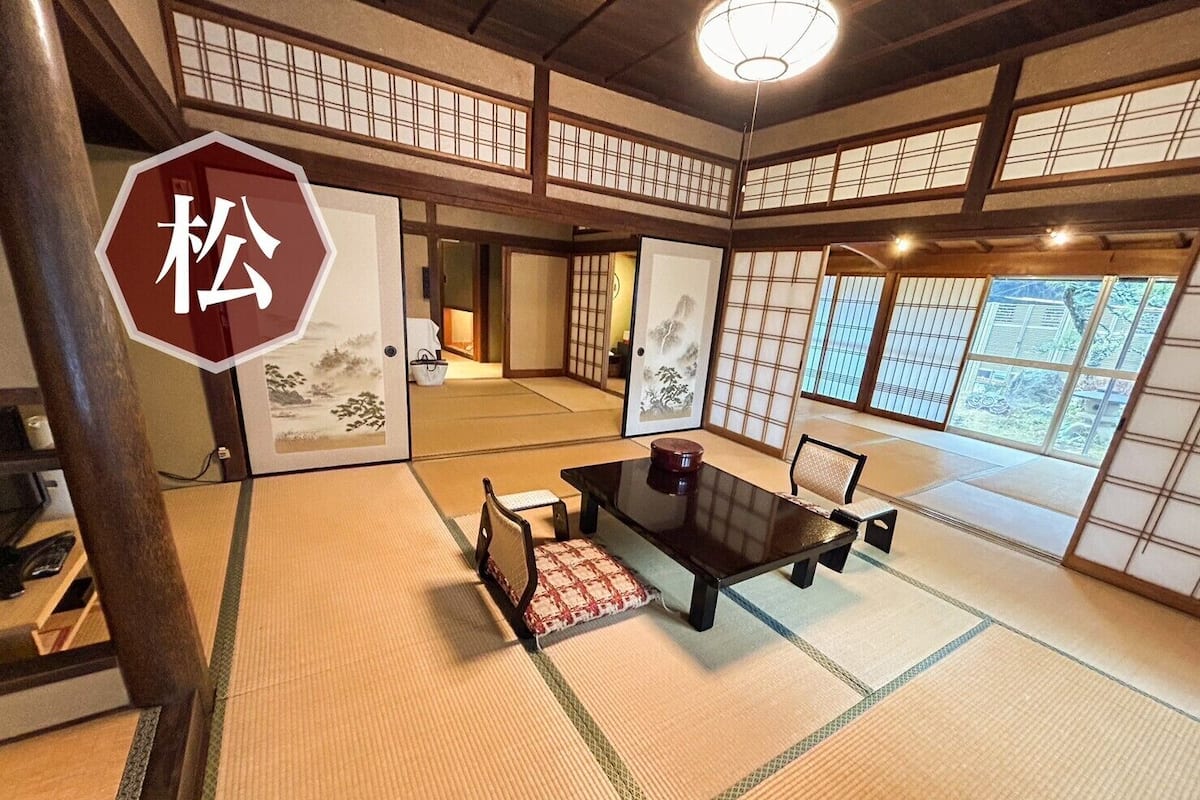 A traditional Japanese room with tatami flooring, a low table, and sliding doors.