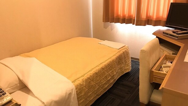 A hotel room with a bed, a desk, a chair, a television, and a telephone. - Garden Hotel Maryell (Gosen)